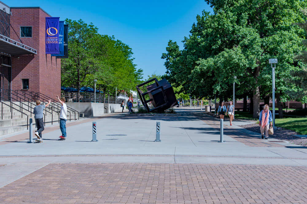 Campus Safety - Students on skateboards and others walking down a sidewalk